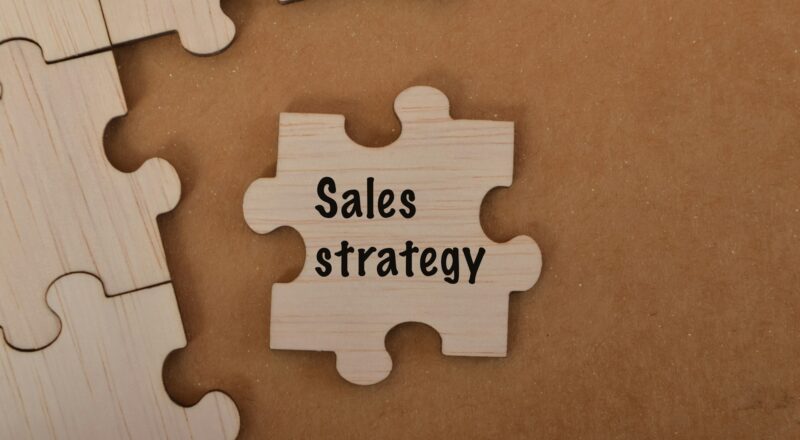 the word SALES STRATEGY is written on jigsaw puzzle.